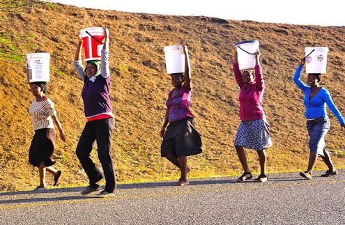 zulu women carrying water buckets on their heads