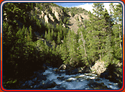 Landscape with mountains, trees, and a running river