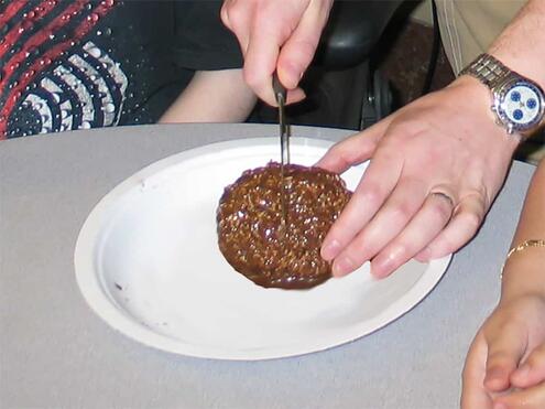 cutting the chocolate covered ball in half with a knife