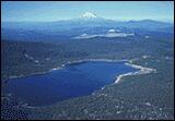 Overhead view of a lake, Medicine Lake in the Cascade Mountains, with a snow capped mountain visible in the distance.