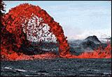 Arch shaped eruption of lava from a dark volcano.
