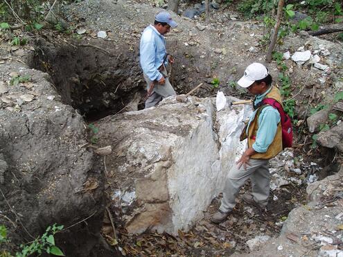 team cutting smaller pieces of jade from large boulder