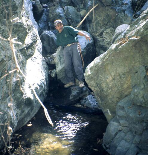 George Harlow between large boulders that have some jade