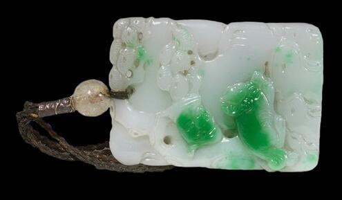 white jade carved pendant with emerald green areas colored by chromium