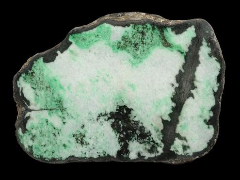 chunk of jade that is vivid green and white with dark streak running through it