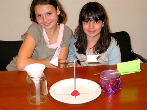 2 girls with their homemade pieces of the weather station