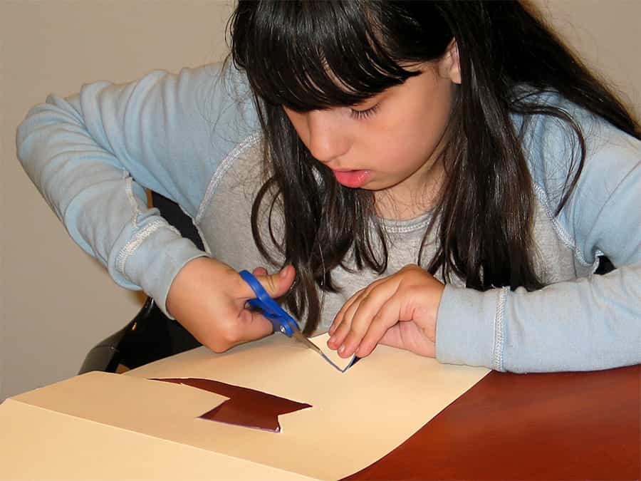 cutting outlines of arrow and tail shapes out of card stock