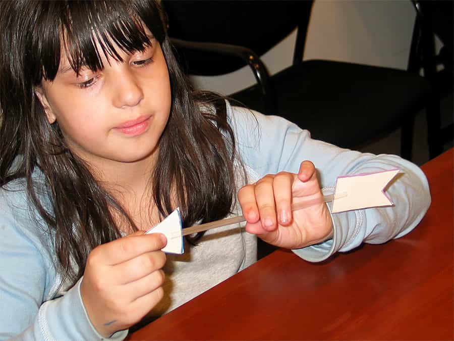 inserting arrow cutout into slits on one end of straw and tail cutout into slits on other end of the straw