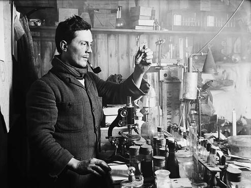 crew member in front of microscope in lab