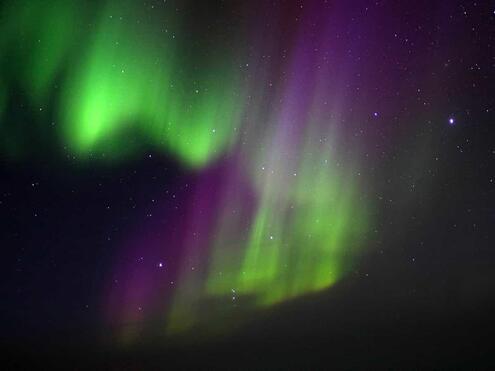 green and purple glowing lights in night sky