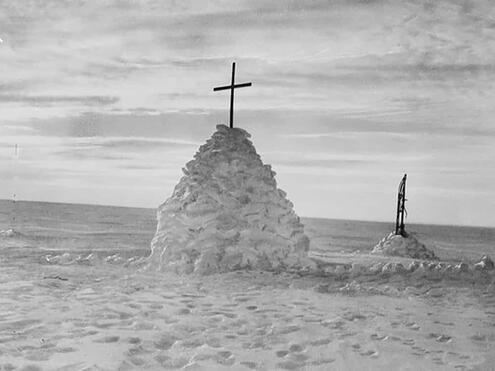 mound of snow built over tent with cross places on top