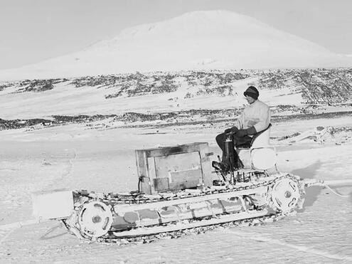 crew member riding motorized sled over terrain