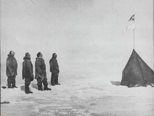 4 Norwegian crew member posing in from to of pitched tent with flag