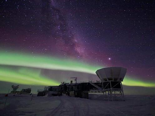 telescope station with green and purple Northern Lights in the sky