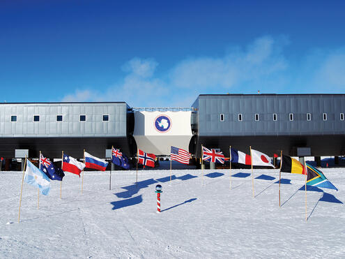 Amundsen-Scott South Pole Station with flags from many nations planted in the snow
