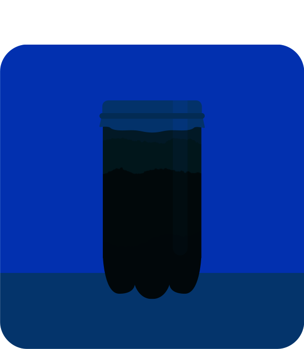 A winogradsky column sitting on a countertop in total darkness.