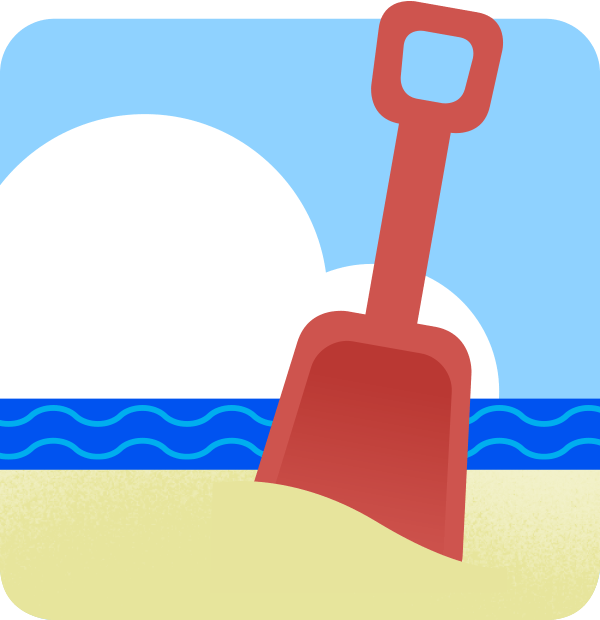 A plastic shovel in beach sand, with the surf and puffy clouds in the background.