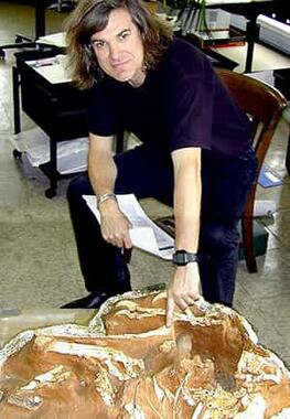 Mark Norell pointing to jacketed fossil