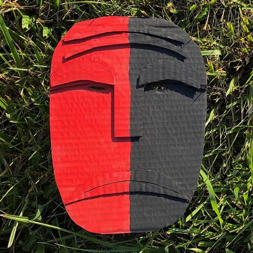 mask made of cardboard that is half red and half dark grey