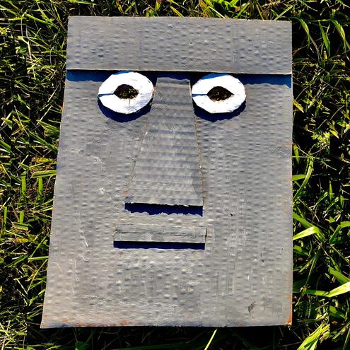 gray cardboard mask with eyes modeled after Moai