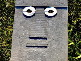 gray cardboard mask with eyes modeled after Moai