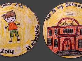 hand drawn coin with year 2014 and a boy on one side and a school on the other side