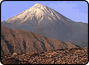 A large, snow-capped mountain in the distance beyond lower hills.