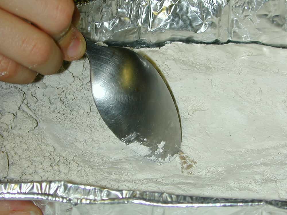 closeup of spoon scraping plaster away from bone