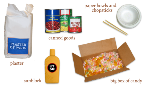 bag of plaster, bottle of sunblock, cans of beans and vegetables, a box filled with hard candy, paper bowls and chopsticks