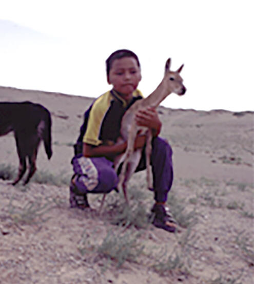 Mongolia child holding a small gazelle