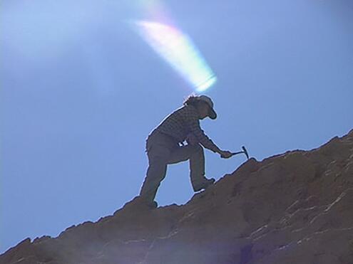 digging on rocky hilltop in blazing sun