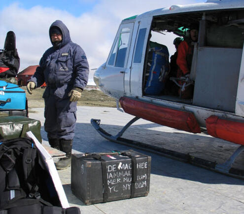 Scientist unloading equipment from a helicopter