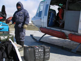 Scientist unloading equipment from a helicopter