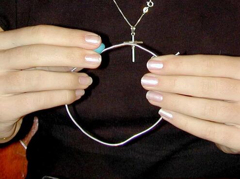 pressing one ball of clay onto small ring of wire