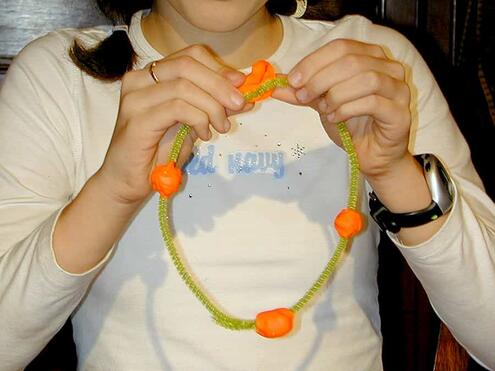 pressing on fourth ball of clay to the large pipe cleaner ring