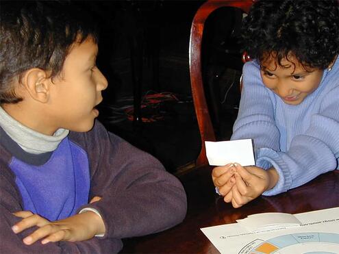 one player reading a trivia card to the other