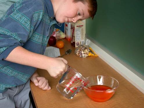 pouring boiling water into bowl with Jell-O powder