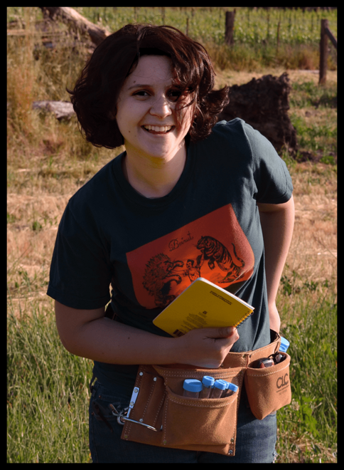 Carly standing outside holding a notebook