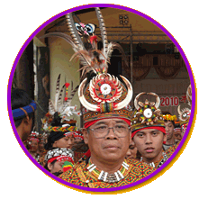 A chief of the Rukai tribe wearing a tall, decorative headdress and a colorful, beaded necklace with people in smaller headdresses behind them.