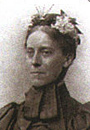 Victorian explorer Mary Kingsley, wearing a floral headband which ties at the neck.
