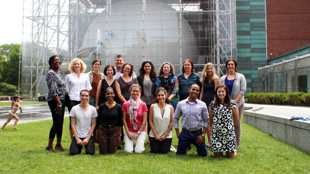 Portrait of the group of sixteen NCEP studio participants, posed outdoors on the lawn in front of the Hayden Planeatarium.