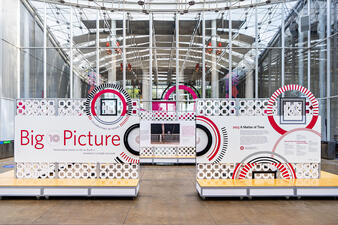 Free-standing exhibition installation walls with text reading "Big Picture" in a large, bright room.