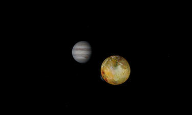Jupiter and its moon Europa appear suspended in darkness