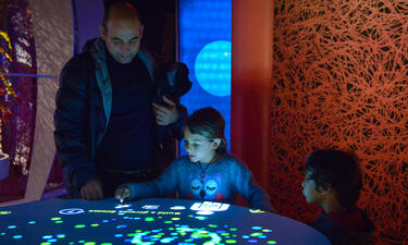 A family interacts with a projection table