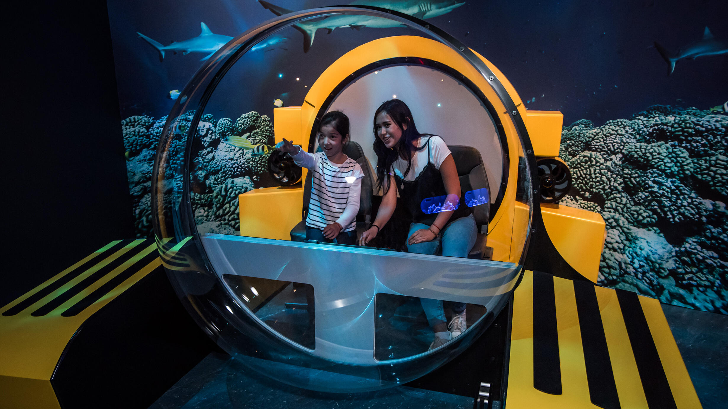 Two female children sit inside a recreated deep-sea Triton submersible