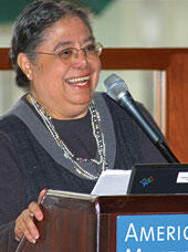 Dr. Maritza Macdonald at podium giving a lecture to her graduate students