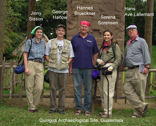 Five people standing and posing in front of a massive ornately carved stela at the Archaeological Park and Ruins of Quirigua in Guatemala.