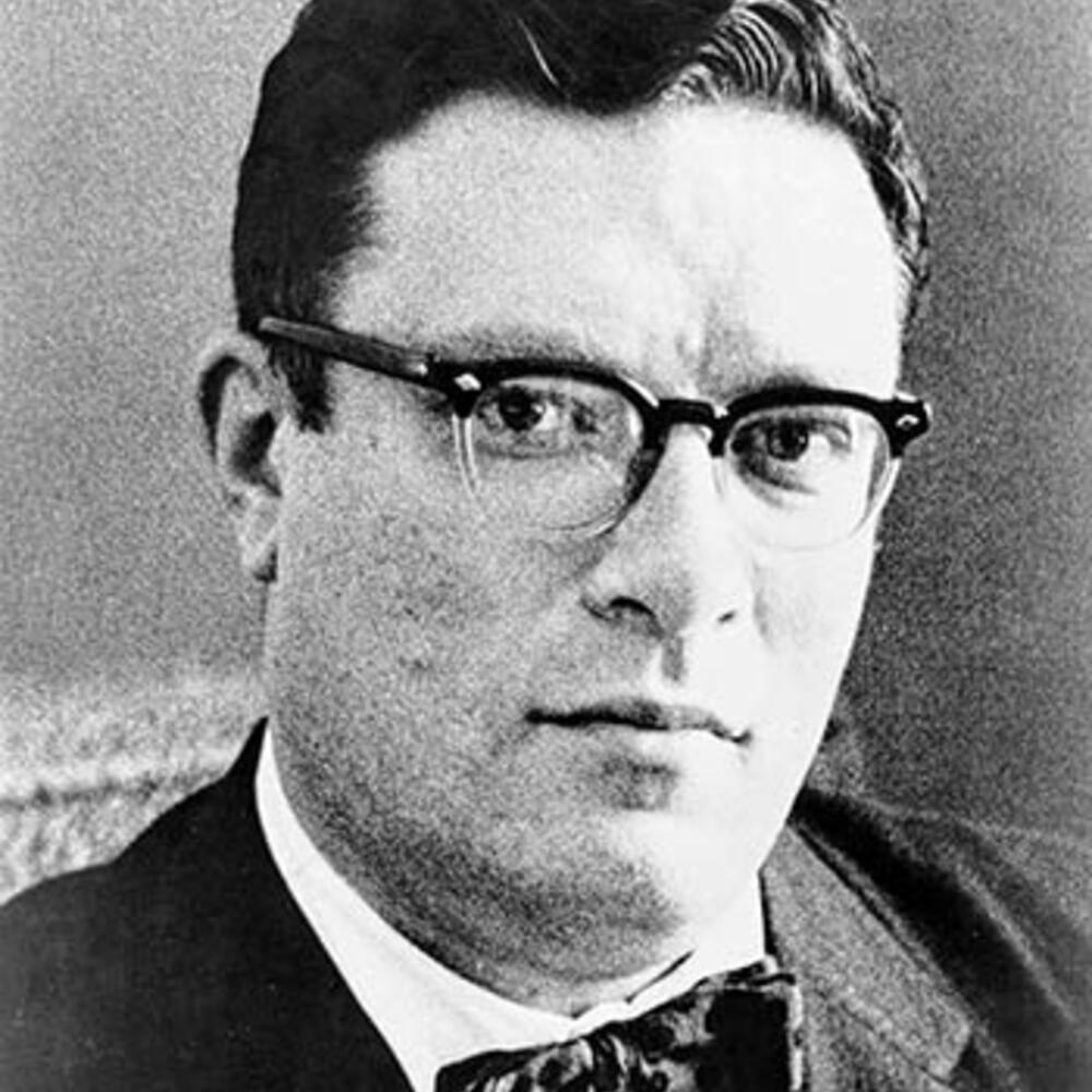 Portrait of a young Isaac Asimov, wearing glasses and a suit with a bowtie.