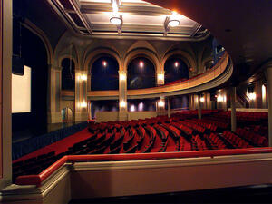 Rows of empty velvet seats face a giant screen inside the Museum's ornately-designed Lefrak theater.