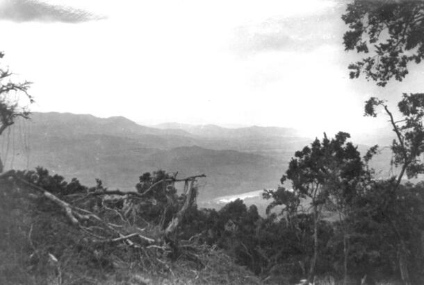 Hill with dense vegetation overlooking a valley with a narrow river and low mountains, captioned Huasteca landscape, northern Veracruz.